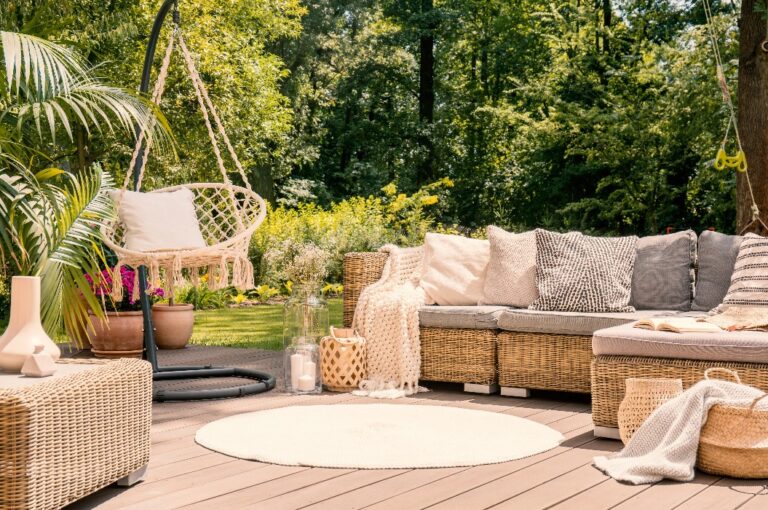 Eine großzügige Terrasse mit einem komfortablen Sofa mit Kissen, einem Tisch und Stühlen.